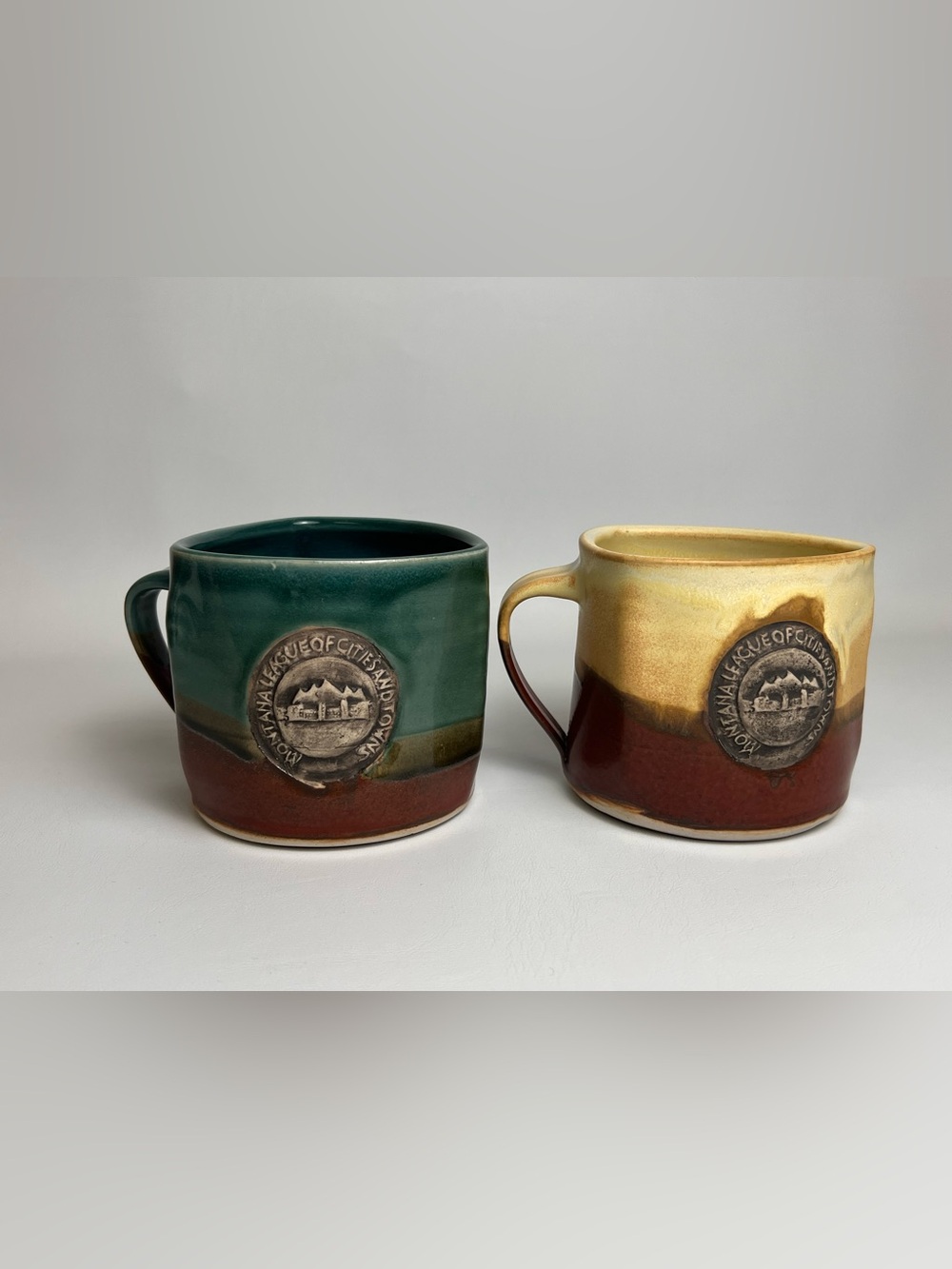 2 Mugs Black Forest Pottery Sarah Dargan Montana League Embossed Logo